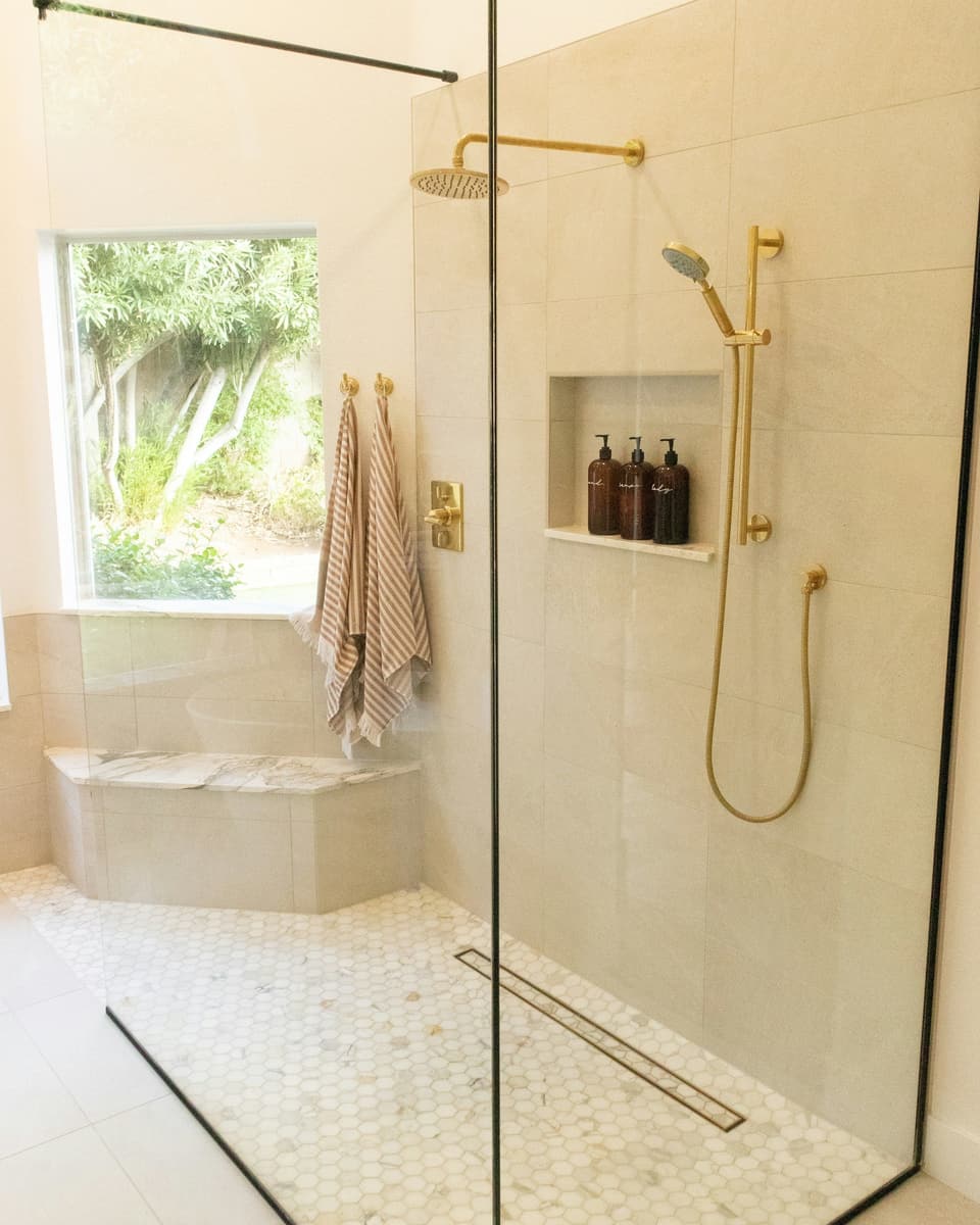 Douche à l'italienne avec paroi vitrée, caniveau et robinetterie en laiton