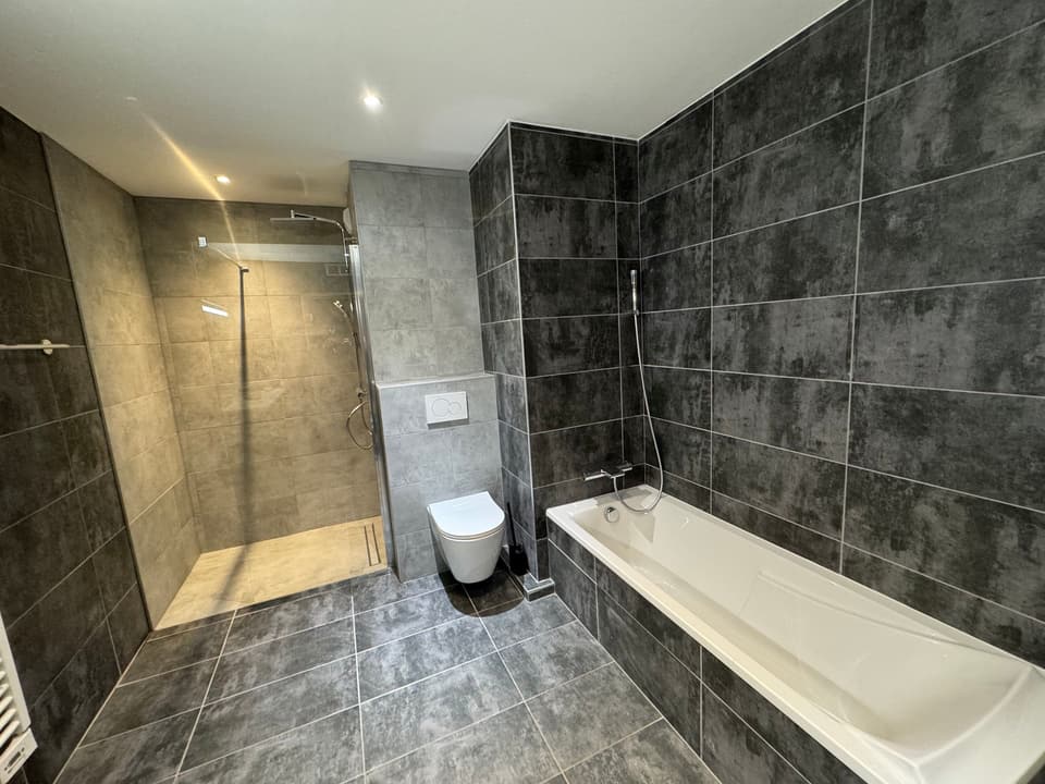 Salle de bain rénovée avec douche à l'italienne, baignoire et WC suspendu, réalisée par KAT Plomberie, plombier à Anthy-sur-Léman